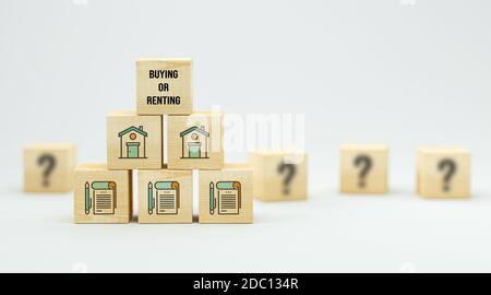 cubes with house symbols and message BUYING OR RENTING on white background - 3d illustration Stock Photo