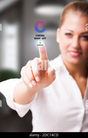 woman is touching a virtual button to download the CORONA WARN APP Stock Photo