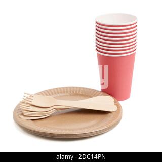 red paper cups and wooden fork, empty round brown disposable plate made from recycled materials isolated on white background, top view. Concept of the Stock Photo