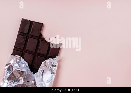 Bited bar of chocolate in foil with crumbs Stock Photo