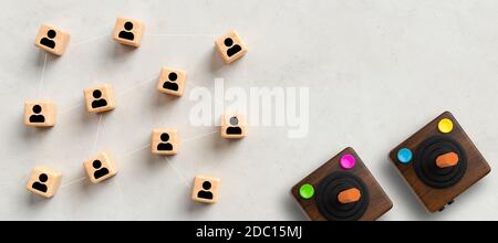 retro gaming controllers and cubes showing a network of people on concrete background Stock Photo