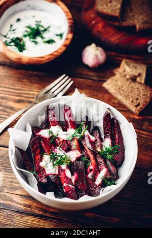 Oven baked beet fries with greek yogurt and dill dressing Stock Photo