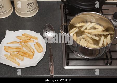 The process of making homemade British potato chips in a chip pan Stock Photo