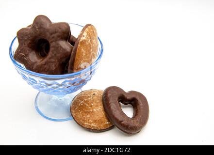 On a white background, a blue glass vase with gingerbread cakes of different sizes and shapes. Stock Photo