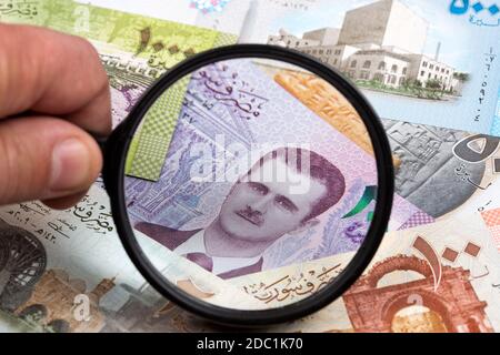 Syrian money in a magnifying glass Stock Photo