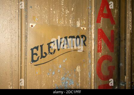 An Old Fashioned Door With Text That Says Elevator on It Stock Photo