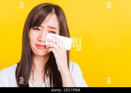 Portrait of Asian beautiful young woman sad she crying wiping tears from eyes with a tissue, Close up of pretty girl feeling depressed upset unhappy, Stock Photo