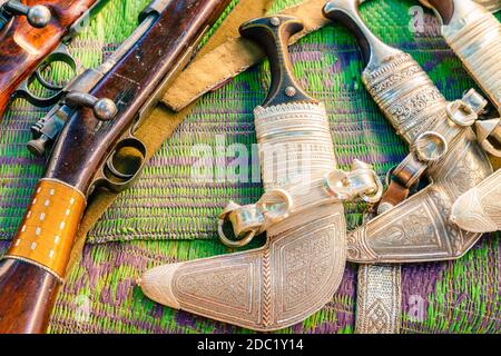 Khanjars and rifles on display at the gun Friday market in Nizwa, Oman Stock Photo