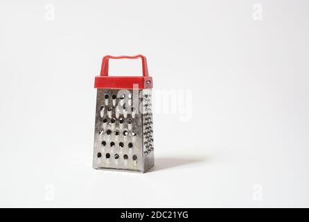 Stainless steel box grater with handle well used for grating cheese and vegetables in kitchen Stock Photo