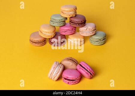 Pastries, desserts and sweets.  Close-up of multicolored original french macaroon cookies are beautiful arranged on a yellow background. Party, birthd Stock Photo