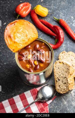 Chili con carne. Mexican food with beans in can on black table. Stock Photo