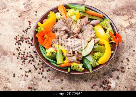 Appetizing beef stew with seasonal vegetables.Sliced pieces of baked beef laid and vegetables Stock Photo