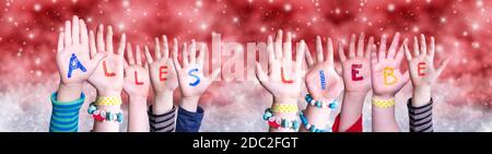 Children Hands Building Colorful German Word Alles Liebe Means Best Wishes. Red Snowy Christmas Winter Background With Snowflakes And Sparkling Lights Stock Photo