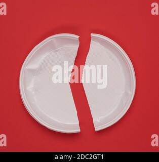 disposable white plastic plate on a red background, top view Stock Photo
