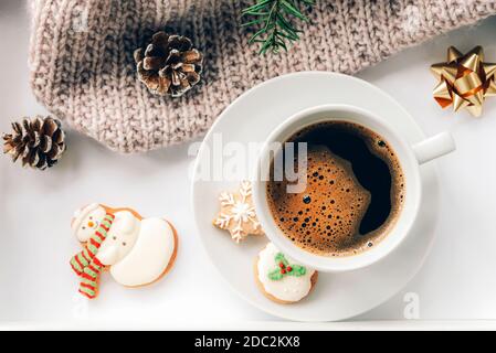 A cup of coffee with gingerbread, a spruce branch, pine cones and a knitted plaid. New Year and Christmas holidays concept. Top view, flat lay. Stock Photo