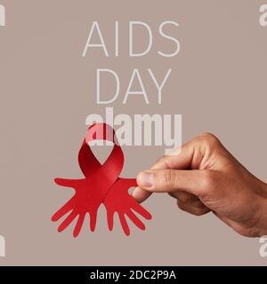 Hand Holding A Red Awareness Ribbon On A Background With Copy Space 