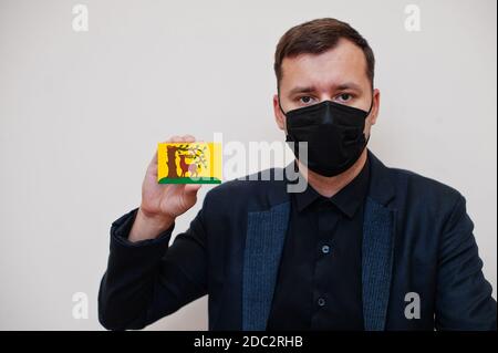 Man wear black formal and protect face mask, hold Berkshire flag card isolated on white background. United Kingdom counties of England coronavirus Cov Stock Photo