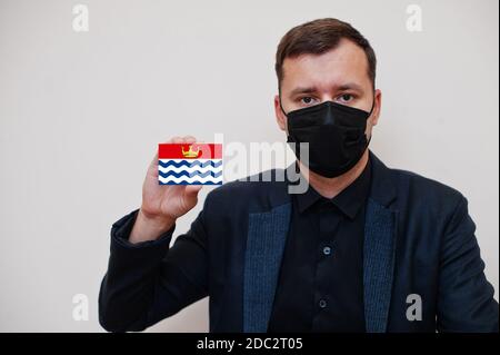 Man wear black formal and protect face mask, hold Greater London flag card isolated on white background. United Kingdom counties of England coronaviru
