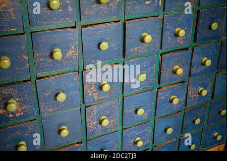 Rows of small wooden drawers with a distressed paint finish. Stock Photo