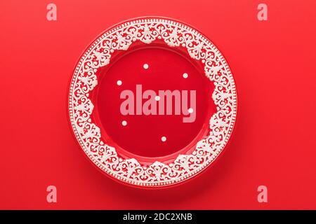 Empty red plate with New Years pattern on a red background, top view Stock Photo