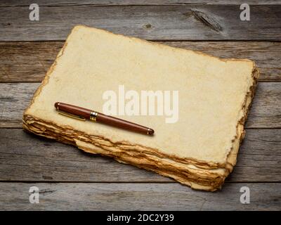 stack of tan toned heavyweight deckle edge paper sheets with a