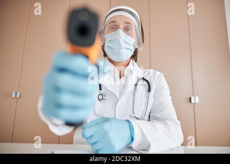 Professional medical worker with a contactless thermometer Stock Photo