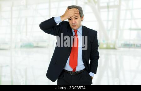 Businessman in a suit gestures with a headache Stock Photo