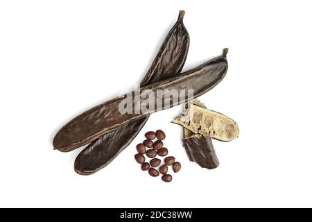Carob beans with seeds isolated on white background. Healthy organic sweet carob pods. Top view. Stock Photo