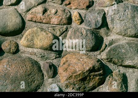 A Unique Random Pattern of Rubble Stone in a Retaining Wall Along the Rocky River. Or Rocks Laid in a Wall Wherever They Would Fit. Stock Photo