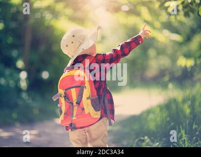 boy going camping in nature. hild with backpack walking in the forest Stock Photo