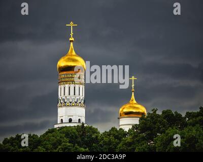 Ivan the Great bell tower in Moscow. Golden domes of the old Cathedral in the Moscow Kremlin before a downpour. Stock Photo