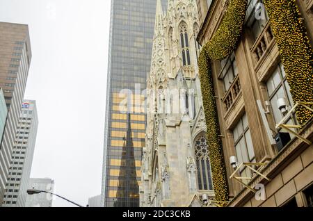 Low Angle View of Saint Patrick's Cathedral Reflected on the Nearby Skyscraper. Manhattan, New York City, USA Stock Photo