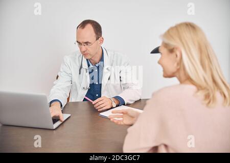Blonde Caucasian woman consulting with the doctor Stock Photo