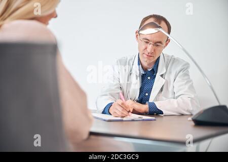 Woman sitting before the physician in his office Stock Photo