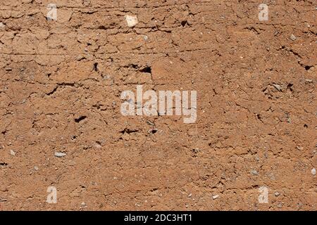 background, texture - brown clay wall with bumps and cracks Stock Photo
