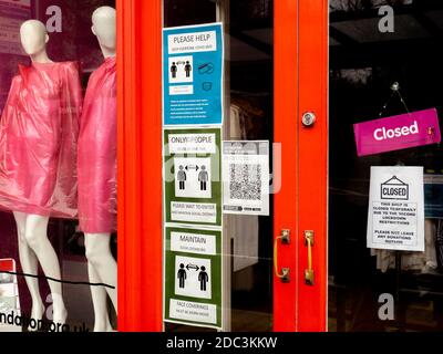 Social distancing guiudlines in the window of charity shop, Shelter, forced to close during the second national lockdown due to coronavirus. Stock Photo