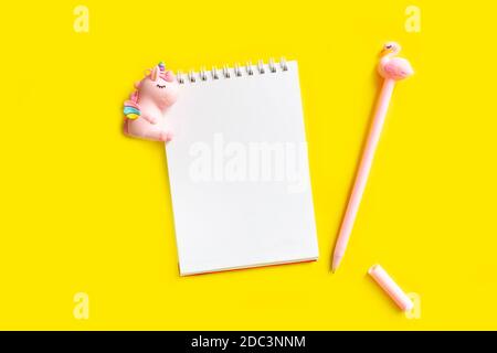 Unicorn. Blank white notepad on a spiral with a pink pen. Top view with copy space, flat lay on yellow background Stock Photo