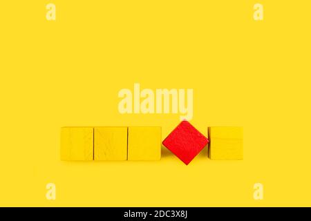 Yellow and red square wooden blocks on a yellow background Stock Photo