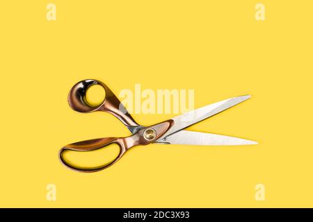 Tailor scissors on a yellow background in a top view Stock Photo