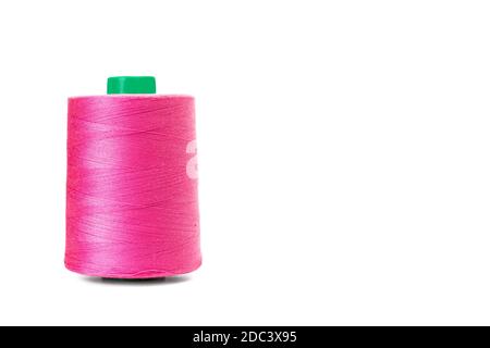 Sewing pink thread spool on a white background with copy space Stock Photo