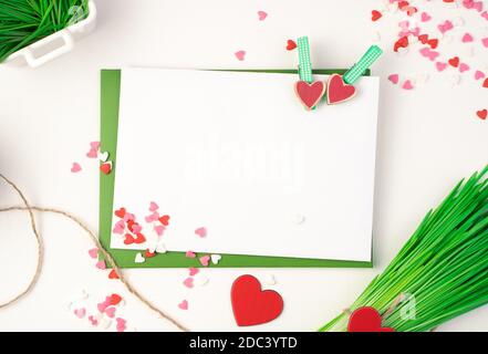 Pink envelope, green bouquet and hearts on a light background. Stock Photo