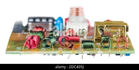 Colored wire winding of air core coils in circuit board on white background. Various red or green RF inductors for receiving high-frequency. Side view. Stock Photo