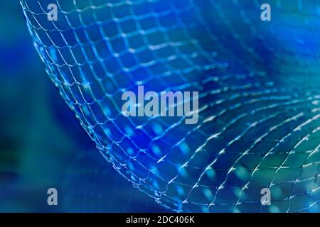 Abstract net detail with reflection on artistic background in blue tone. Closeup of dynamic wavy grid pattern in surreal futuristic space. Scifi. Tech. Stock Photo