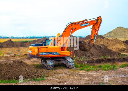 Anapa, Russia-13.07.2020: An excavator digs the ground at a construction site. Construction of a traffic intersection Stock Photo