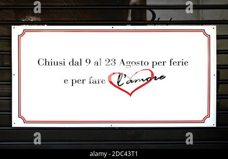 Closed for holiday and to make love, written on a sign on a closed shutter of a shop. Summer season holidays. Rome, Italy, Europe