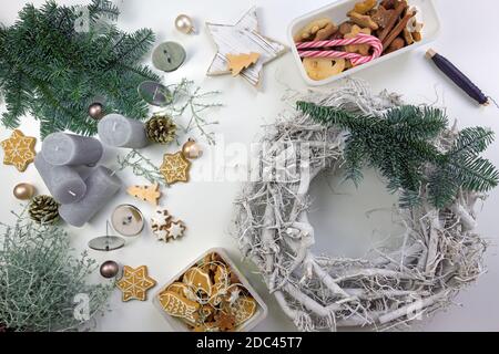 Homemade advent wreath from wood decorate with fir branches, gingerbread cookies, christmas ornaments and candles, high angle view from above Stock Photo