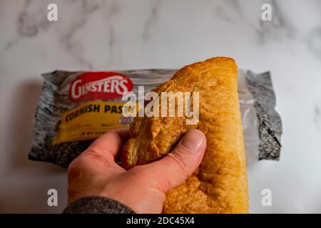 Norwich, Norfolk, UK – November 17 2020. An illustrative photo of a Ginsters readymade traditional Cornish pasty on a marbled white surface Stock Photo