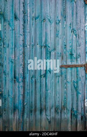 Vintage wooden background with faded turquoise peeling paint. Old wooden painted texture surface. Shabby Planks with cracked color paint. Stock Photo