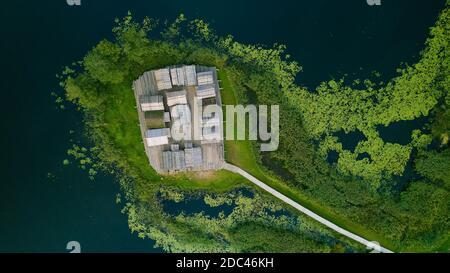 View from above of ancient wooden settlement on river island. Recontruction of traditional architecture. Stock Photo