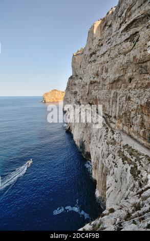 Stairway in limestone rock to stalactite Neptune cave. Boat sailing to Grotte di Nettuno in Sardinia Stock Photo